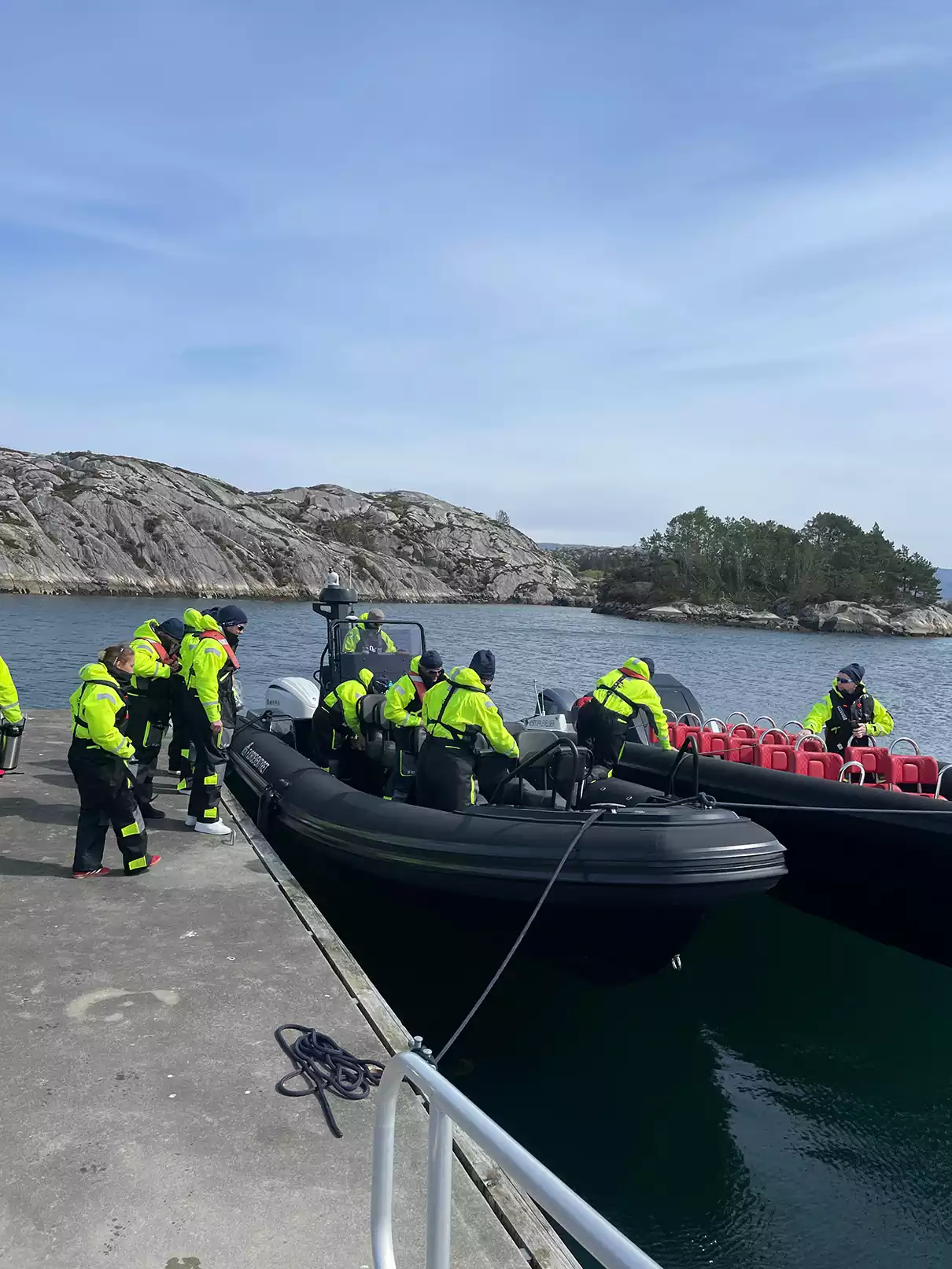 Passasjerer går om bord i en RIB-båt ved kai